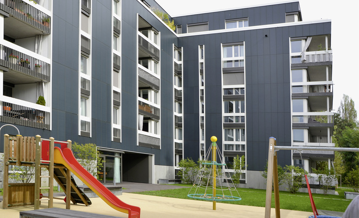 Leicht wie ein Textilstoff: Trotz der dunklen Farbe der -Solarfassade wirkt der Neubau in Allschwil aufgelockert. - © Foto: Velka Botička Leicht wie ein Textilstoff: Trotz der dunklen Farbe der -Solarfassade wirkt der Neubau in Allschwil aufgelockert.