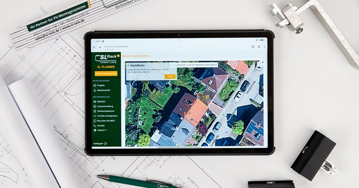 Tablet mit einer Satellitenkarte von Häusern, die auf Architekturplänen platziert sind, mit Zeichenwerkzeugen in der Nähe. - © SL Rack