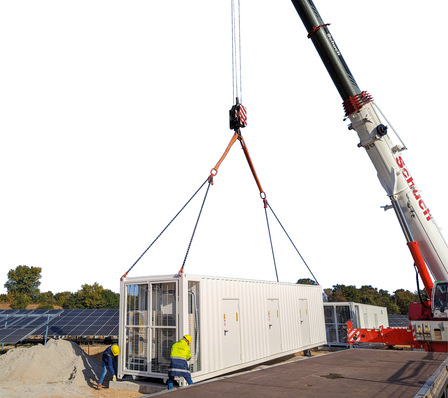 © Foto: EnBW Ein Batteriespeicher wird durch einen Schwerlastkran auf das Fundament gehoben.