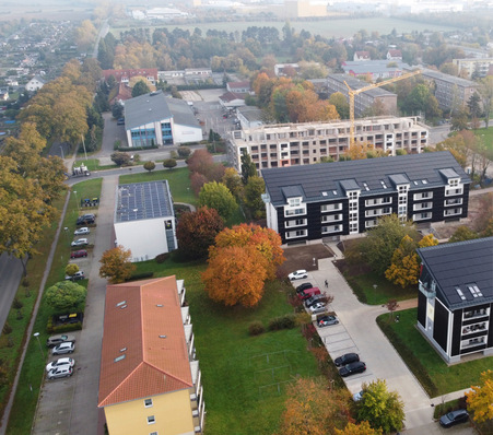 © Foto: Timo Leukefeld GmbH Ein Blick auf die Plattenbauten in Aschersleben: Die vorderen beiden Gebäude wurden schon saniert. Der hintere Plattenbau soll Ende 2025 bezugsfertig sein.
