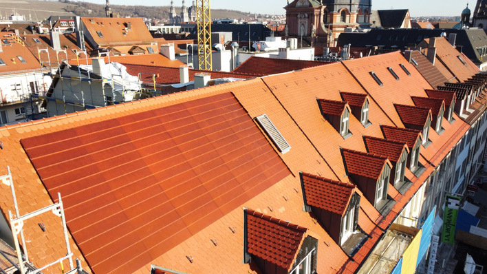 © Nelskamp Die roten solaren Dachelemente fügen sich fast perfekt in die Dachhaut des historischen Gebäudes in Würzburg ein. Unweit des Doms war aus denkmalschützerischen Gründen keine andere Lösung möglich.